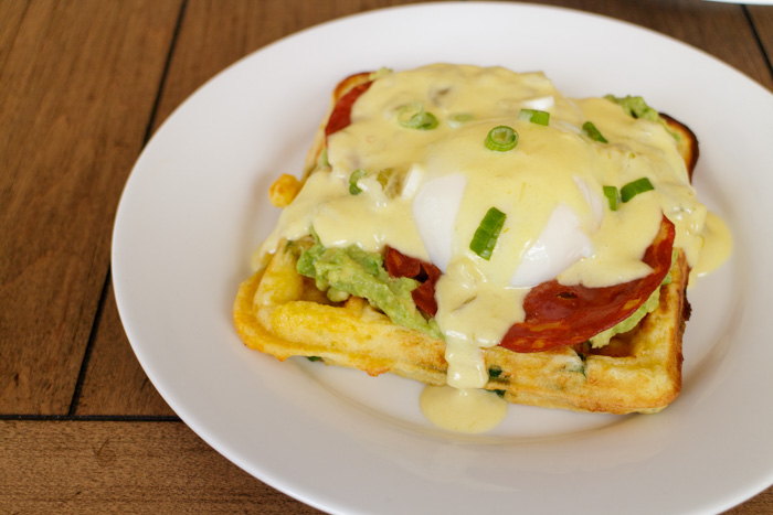 Eggs Benedict Over Cheddar Scallion Waffles with Crispy Chorizo, Smashed Avocado and Green Chile Hollandaise